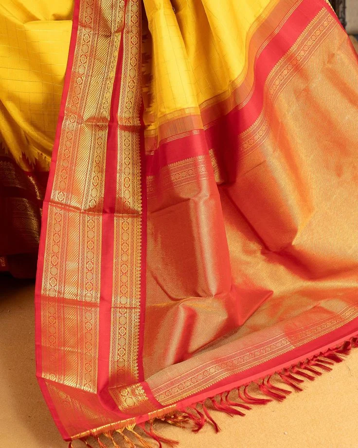 Yellow and red Kanjivaram silk saree with heavy gold zari border